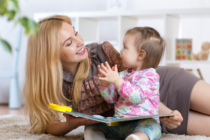 child girl and mother read a book indoors