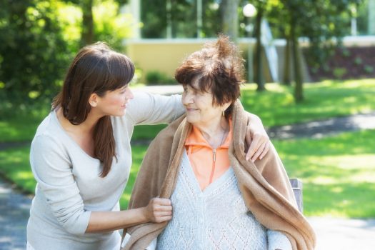 Seniorenbetreuung Junge Frau hilft Seniorin beim spaziergang